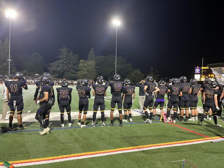 AV Varsity Football players stay alert as they await their turn to join the game on the field.