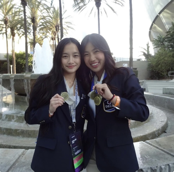 Chloe Fan, on the right, celebrates with chief financial officer of DECA Kacie Hu.